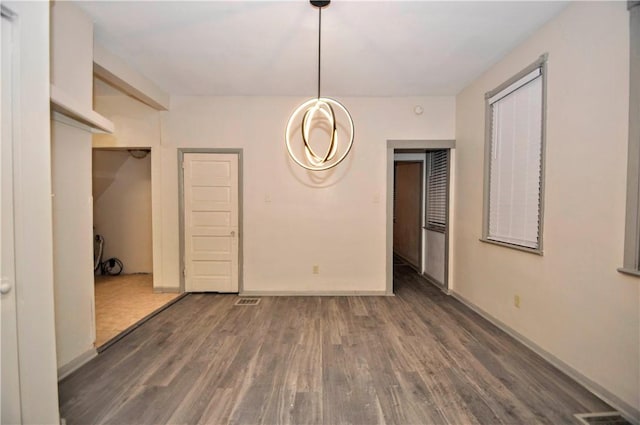 unfurnished dining area featuring dark wood-type flooring