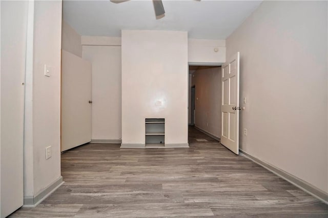 empty room with ceiling fan and light hardwood / wood-style floors