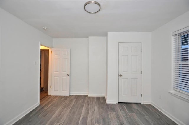 unfurnished bedroom featuring a closet and dark hardwood / wood-style flooring