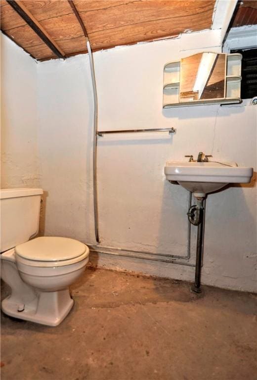 bathroom with concrete flooring and toilet