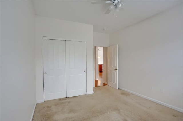 unfurnished bedroom with ceiling fan, light colored carpet, and a closet