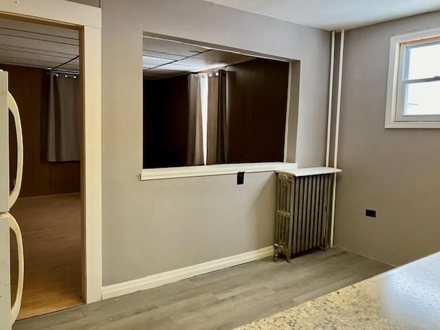 corridor featuring light hardwood / wood-style floors and radiator heating unit