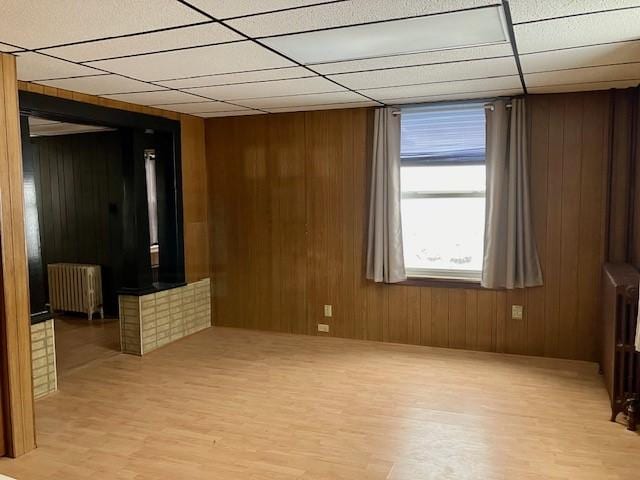 spare room featuring radiator heating unit and wooden walls