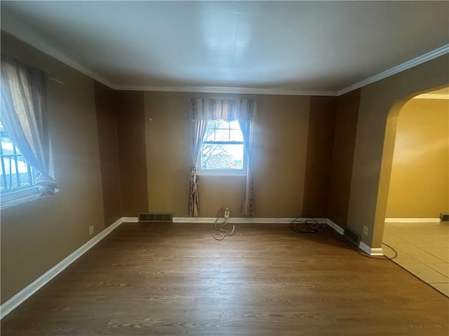 spare room featuring wood-type flooring and ornamental molding