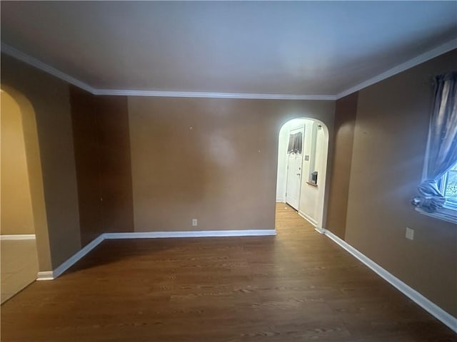 empty room featuring wood-type flooring and ornamental molding