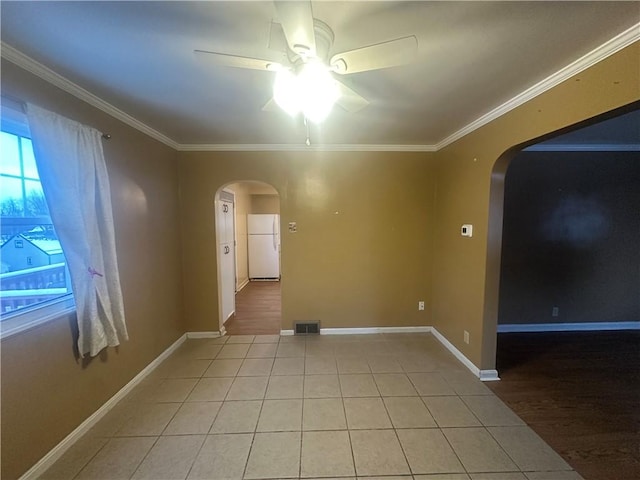 unfurnished room featuring ceiling fan, light tile patterned floors, and ornamental molding