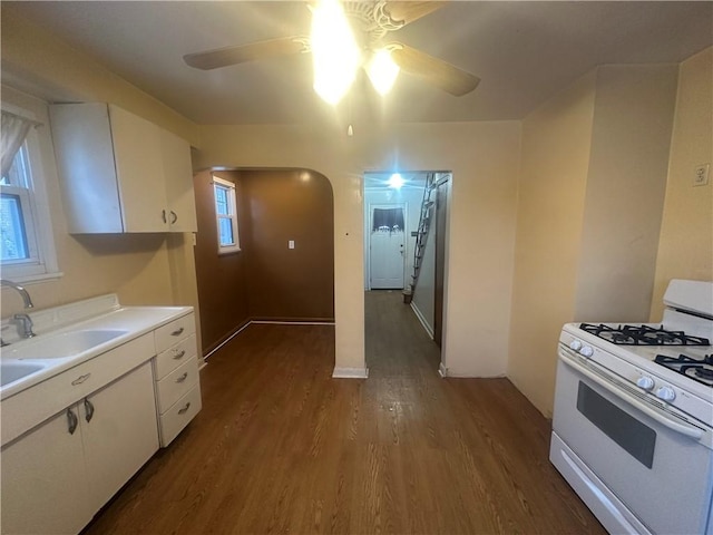 kitchen featuring white cabinets, white gas range oven, ceiling fan, and sink