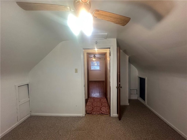 additional living space featuring dark colored carpet and lofted ceiling