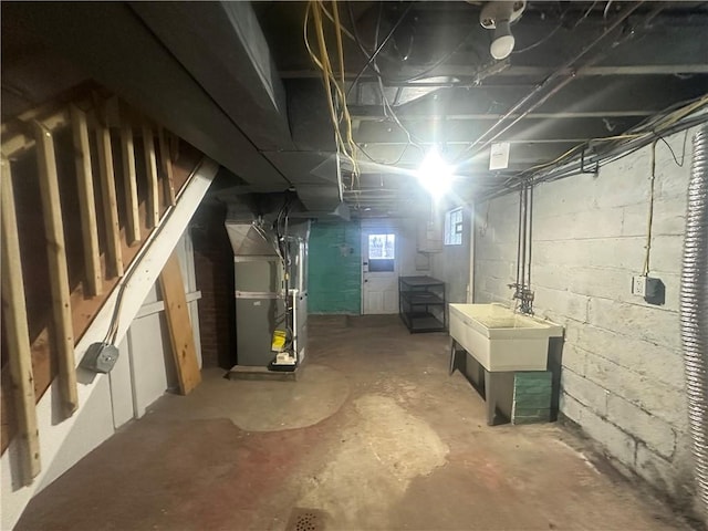 basement featuring heating unit and sink