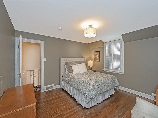 bedroom with dark hardwood / wood-style flooring