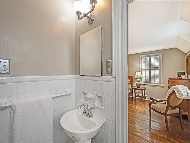 bathroom with sink, wood-type flooring, and vaulted ceiling