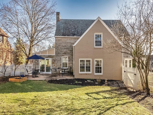 back of property with a yard and a patio