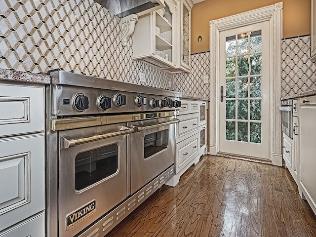 kitchen with white cabinets, dark hardwood / wood-style flooring, range with two ovens, and backsplash