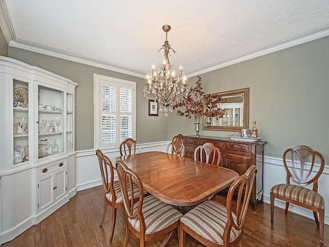 dining room featuring crown molding, dark hardwood / wood-style flooring, and a chandelier