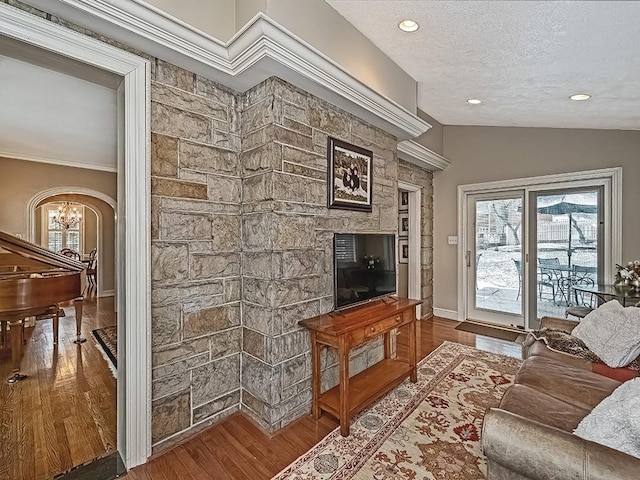 living room with hardwood / wood-style floors, a notable chandelier, lofted ceiling, and a textured ceiling