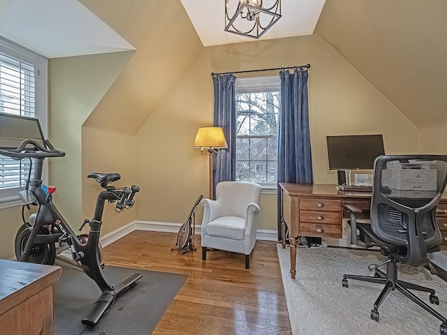 office featuring hardwood / wood-style floors, an inviting chandelier, vaulted ceiling, and a healthy amount of sunlight