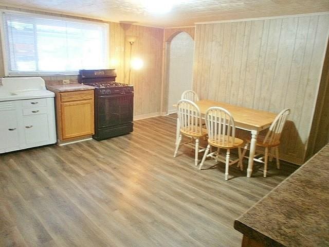 dining area with light wood-type flooring and wooden walls