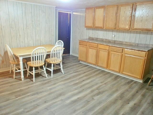 kitchen with wood walls and light hardwood / wood-style floors