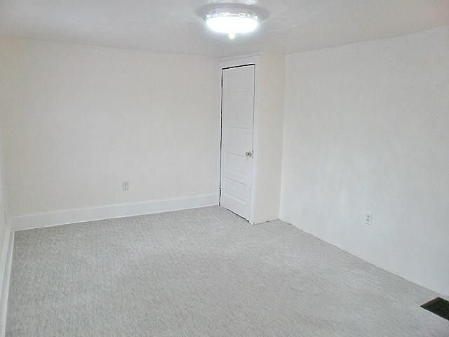 unfurnished room featuring light carpet