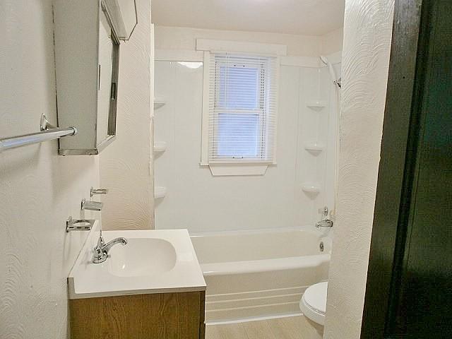 full bathroom with hardwood / wood-style floors, vanity, toilet, and tub / shower combination