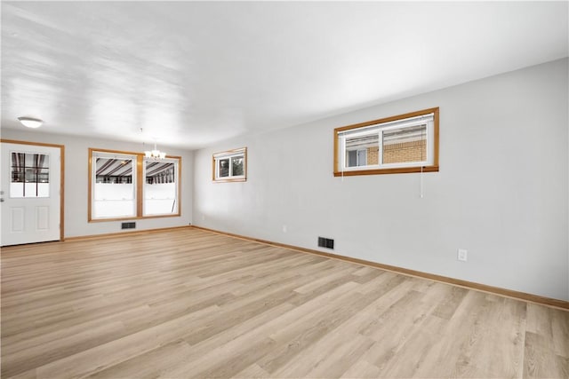 unfurnished room with light hardwood / wood-style floors and a chandelier