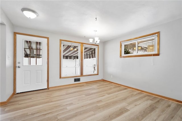 interior space featuring light wood-type flooring and an inviting chandelier