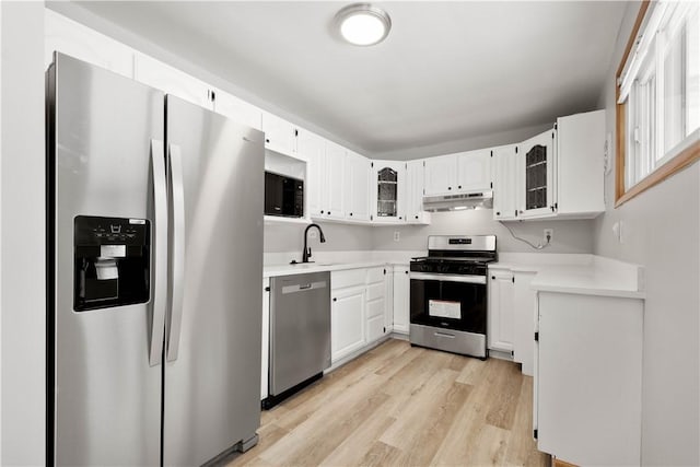 kitchen with light wood-type flooring, white cabinetry, sink, and appliances with stainless steel finishes