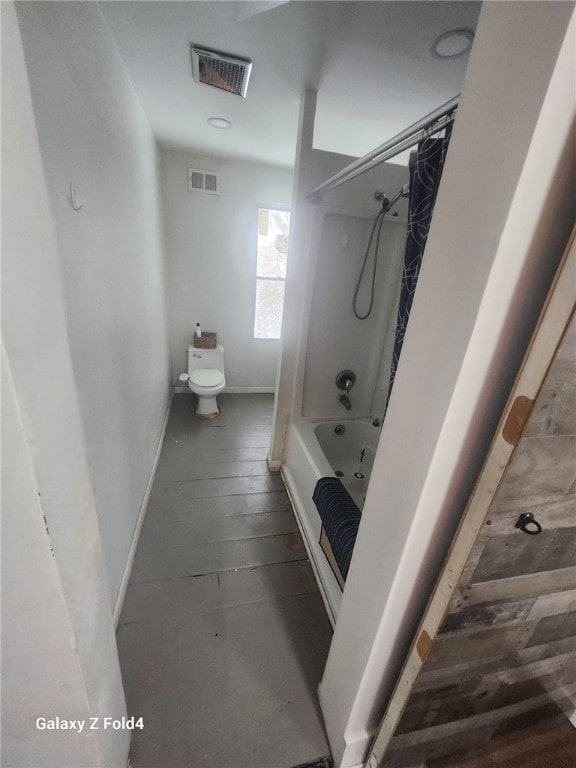 bathroom featuring toilet and shower / tub combo with curtain