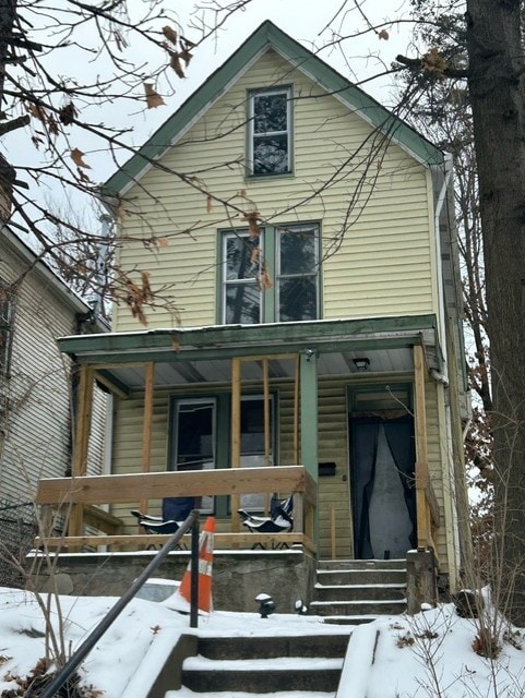 snow covered property with a porch