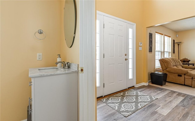 entryway with light hardwood / wood-style flooring and sink