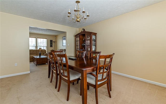 carpeted dining area with a textured ceiling and a notable chandelier