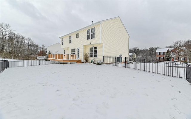 snow covered house with a wooden deck