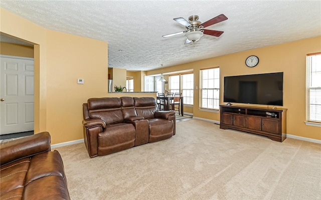 carpeted living room featuring ceiling fan and a textured ceiling