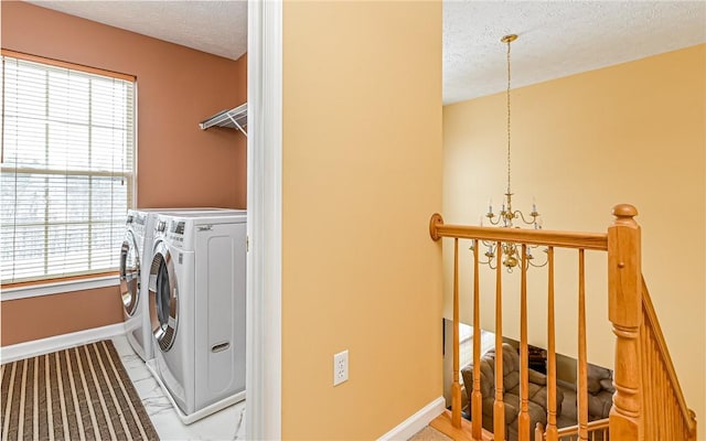 clothes washing area featuring a chandelier, independent washer and dryer, and a textured ceiling