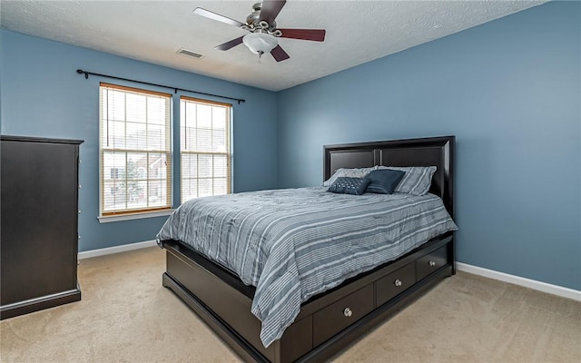 carpeted bedroom with ceiling fan and a textured ceiling