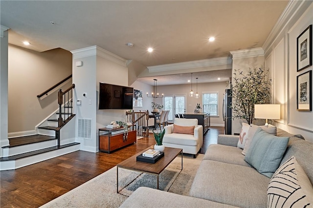 living room with a chandelier, dark hardwood / wood-style floors, and ornamental molding