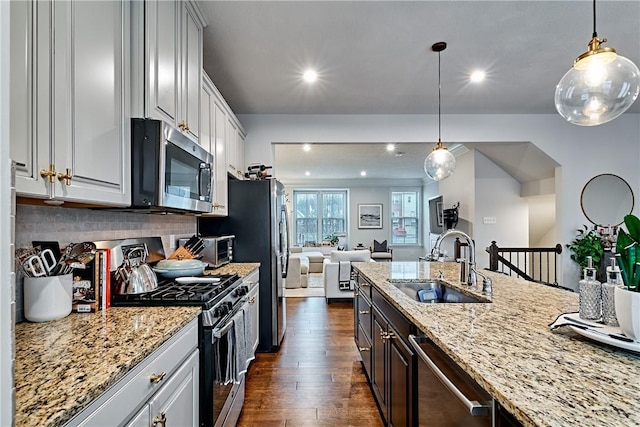 kitchen featuring decorative backsplash, appliances with stainless steel finishes, sink, pendant lighting, and white cabinets