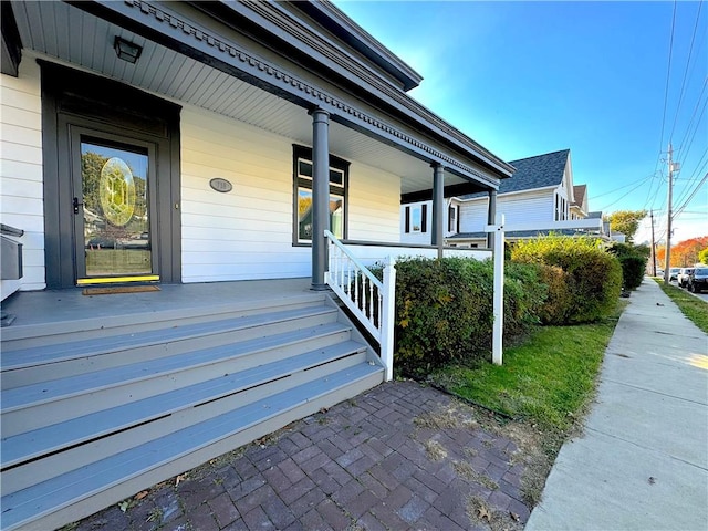 view of exterior entry featuring covered porch