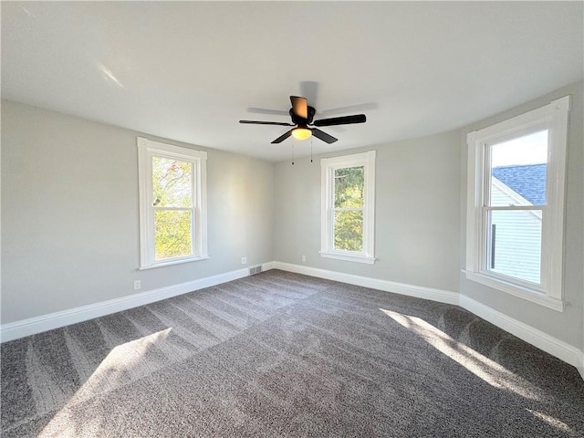 carpeted spare room featuring plenty of natural light and ceiling fan