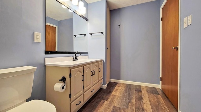 bathroom with hardwood / wood-style flooring, vanity, and toilet