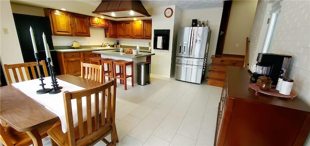 kitchen featuring sink, an island with sink, a breakfast bar area, black appliances, and custom range hood