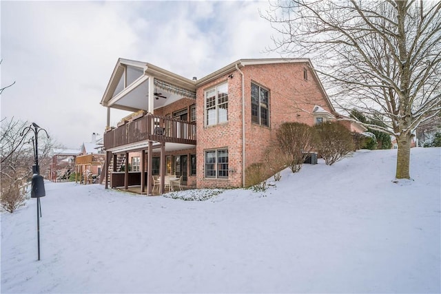 snow covered property featuring ceiling fan and a balcony