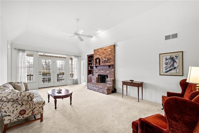 carpeted living room featuring ceiling fan, high vaulted ceiling, and a brick fireplace