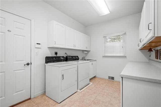 washroom with sink, light tile patterned floors, cabinets, and independent washer and dryer