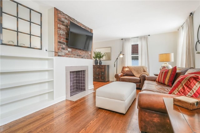 living room with light wood-type flooring and built in features