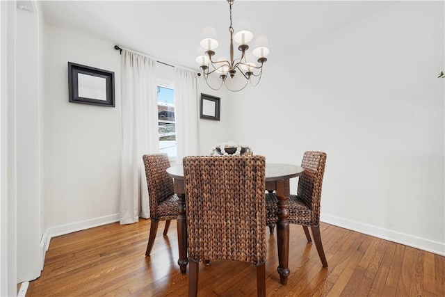 dining area featuring hardwood / wood-style floors and a notable chandelier