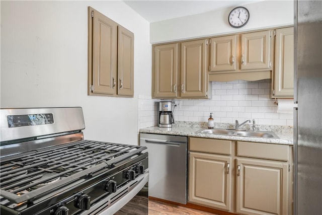 kitchen with stainless steel appliances, tasteful backsplash, light hardwood / wood-style floors, and sink