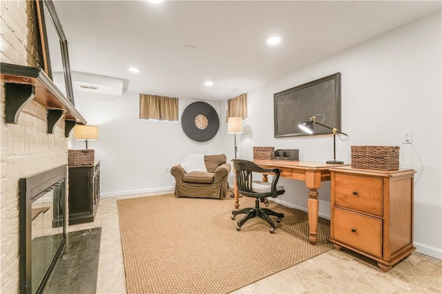 office space with a stone fireplace