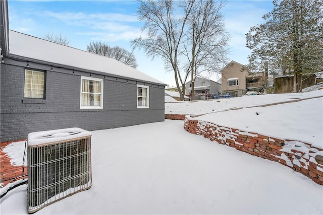 view of snow covered exterior featuring central AC unit