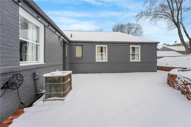 view of snowy exterior featuring central AC